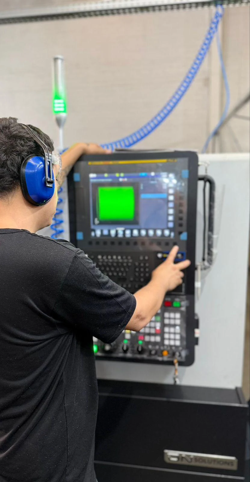 Profissional operando o painel de um torno CNC